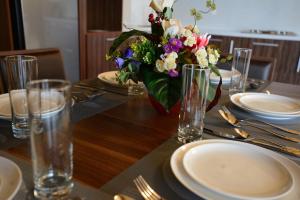 a table with plates and a vase of flowers on it at City Line Boutique Hotel in Tashkent