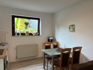 a dining room with a table and chairs and a window at Waldnest ,Moderne Ferien und Monteurwohnung in Ardey +8 photos