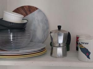 a coffee maker sitting on a shelf next to plates at Quiet and Cozy Cunuco apartment in Savaneta