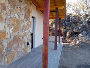 a building with a stone wall and a wooden porch at VenTeVeo Chakra de Montaña in Atos Pampa +65 photos