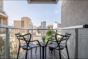 a balcony with two chairs and a table with a plant at Modern Studio in Palermo Hollywood in Buenos Aires