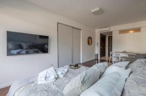a bedroom with a couch and a tv on the wall at Modern Studio in Palermo Hollywood in Buenos Aires