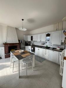 a kitchen with white cabinets and a table and chairs at PANORAMA Cremia-casa LINA in Cremia