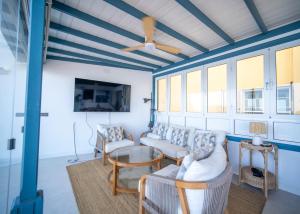 Una sala de estar con sofás, una mesa y ventanas. en RYETE Playa Blanca, en Playa Blanca