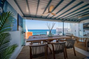 Un comedor con mesa y sillas y el océano. en RYETE Playa Blanca, en Playa Blanca 14 fotos más