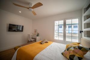 Un dormitorio con una cama y un ventilador de techo. en RYETE Playa Blanca, en Playa Blanca