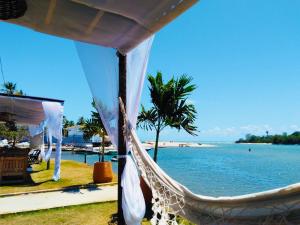 a hammock in front of a beach with the ocean at Casa da Barra99 in Francês