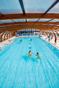 a group of people in a swimming pool at Camping Officiel Siblu Domaine de Litteau in Litteau