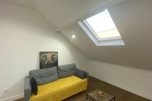 a living room with a yellow couch and a window at Appartement cosy in Creil