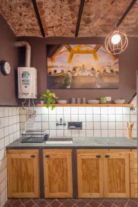 a kitchen with a sink and a painting on the wall at Maison Depla with rooftop, Jacuzzi, pool, and BBQ in Buenos Aires