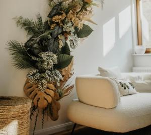 a living room with a chair and a flower arrangement on the wall at Modern Boho-Style Apartment in Deidesheim