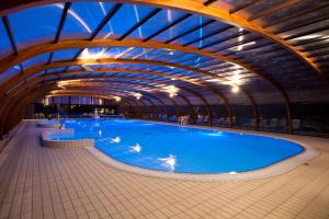 una gran piscina en un gran edificio en Camping Officiel Siblu Domaine de Litteau en Litteau