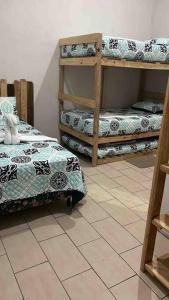 a room with two bunk beds and a tiled floor at Casa Shanti, Villa en la Playa in El Cebollito