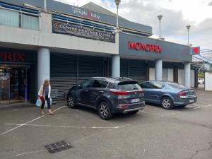 two cars parked in a parking lot in front of a store at Studio rez-de-chaussée in Bougival