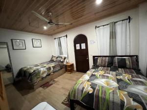 a bedroom with two beds and a door at Apartamentos Mansión Tropical in Quepos