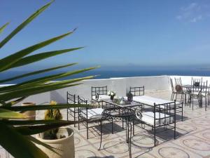 Un patio con mesas y sillas y el mar. en Room in Tangier, Morocco F, en Tánger