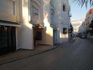 Una calle vacía con edificios blancos en una calle de la ciudad. en Room in Tangier, Morocco F, en Tánger 2 fotos más