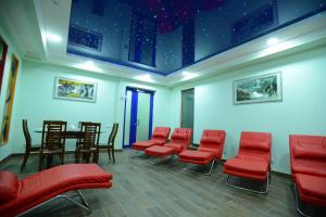 a waiting room with red chairs and a table at City Line Boutique Hotel in Tashkent