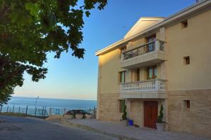 a building with a balcony and the ocean in the background at Villa Katalina in Varna City