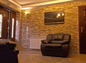 a living room with a chair and a television on a brick wall at Villa Katalina in Varna City