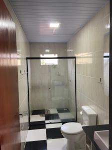 a bathroom with a toilet and a glass shower at Casa na Praia de Canoas in Pontal do Paraná +15 photos