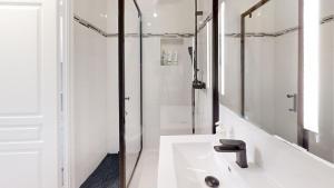 a white bathroom with a sink and a shower at Résidence Calme au Bord de Seine à Melun avec Jardin Terrasses et vue sur la Seine in Le Mée-sur-Seine +41 photos