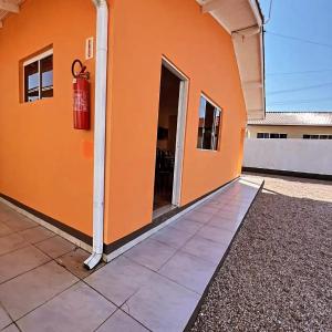 an orange building with a fire hydrant on the side at Refugio da Camboa - Casa Laranja in Armação +2 photos