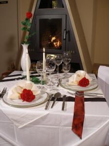 einen Tisch mit Tellern und Weingläsern sowie einen Kamin in der Unterkunft Landgasthof Zum Wolfsberg in Dietfurt
