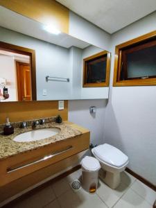 a bathroom with a sink and a toilet at Apartamento em Tramandaí in Tramandaí +34 photos
