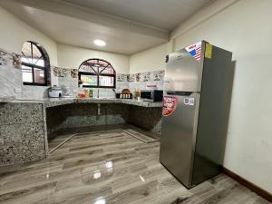 a kitchen with a stainless steel refrigerator in a room at Hospedaje Nacho y Ale 1, con 3 AC, Paso Canoas, CR in Canoas