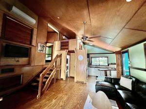 a living room with a couch and a ceiling fan at Tropical Cabin Retreat in Mission Beach