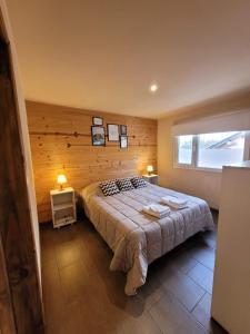 a bedroom with a large bed and a window at Baguales Alojamientos Patagonicos in Villa La Angostura