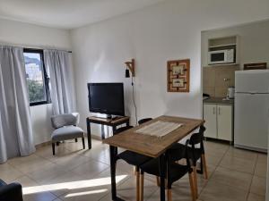 a living room with a table and a kitchen at Apart Origenes in Villa Regina +17 photos