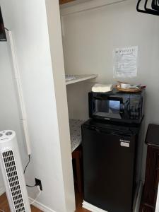 a microwave sitting on top of a black refrigerator at The Hub in Del Aire
