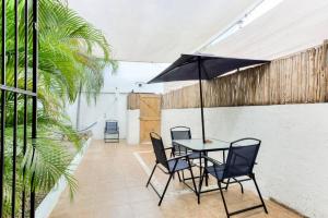 a table with chairs and an umbrella on a patio at M&Z Loft Las Palmas in Cancún