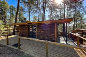 a log cabin on a deck in the woods at Great Little Cabin! in Ruidoso