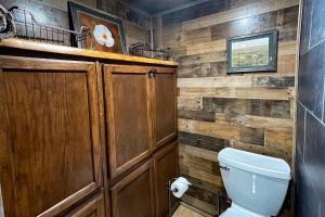 a bathroom with a toilet and a wooden wall at Great Little Cabin! in Ruidoso +11 photos