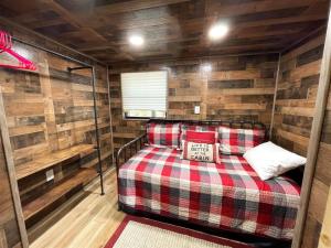 a room with a bed in a cabin with wooden walls at Great Little Cabin! in Ruidoso