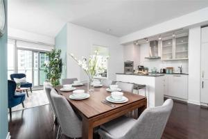 a kitchen and dining room with a wooden table and chairs at Superior Lakeview Luxury 3-Bedroom Suite on High Floor in Toronto
