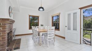 Un comedor con mesa y sillas y chimenea. en Classic Holiday House, en Woorim