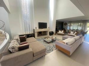 a large living room with couches and a tv at Casa Luxuosa no Condomínio Villaggio Atlântida in Xangri-lá +17 photos