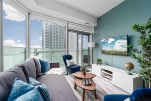 a living room with a couch and a tv at Superior Lakeview Luxury 3-Bedroom Suite on High Floor in Toronto