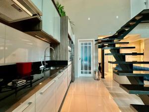a kitchen with white cabinets and a black staircase at Apartamento Luxuoso de 2 Dormitórios in Capão da Canoa +11 photos