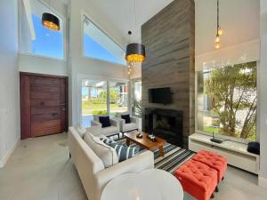 ein Wohnzimmer mit weißen Möbeln und einem Kamin in der Unterkunft Casa Luxuosa no Condomínio Ilhas Resort in Capão da Canoa + 14 Fotos