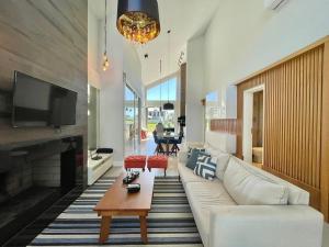 ein Wohnzimmer mit einer weißen Couch und einem Kamin in der Unterkunft Casa Luxuosa no Condomínio Ilhas Resort in Capão da Canoa