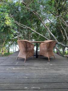 two wicker chairs sitting on top of a wooden deck at Infinito in Puerto Valle