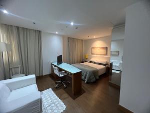 a bedroom with a bed and a desk with a computer at Flat Jardins Paulista 540 in Sao Paulo +15 photos