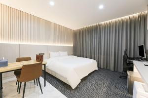 Una habitación de hotel con una cama, un escritorio y una computadora. en Daegu Hotel Series Lions Park, en Daegu