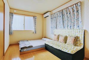 a small bedroom with a bed and a window at ABC Guest House 2F in Izumi-Sano