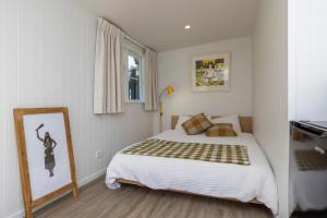 een kleine slaapkamer met een bed en een raam bij Otaki Beach Guesthouse in Otaki Beach